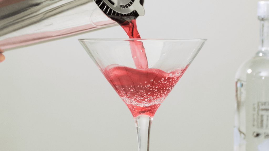 Iced Berry Tea Sparkler being poured into a martini glass.