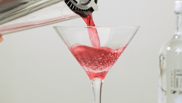 Iced Berry Tea Sparkler mocktail being poured into a martini glass.